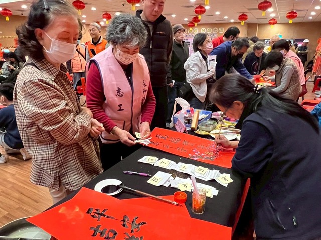 書法老師聚精會神依民眾需求書寫春聯字畫